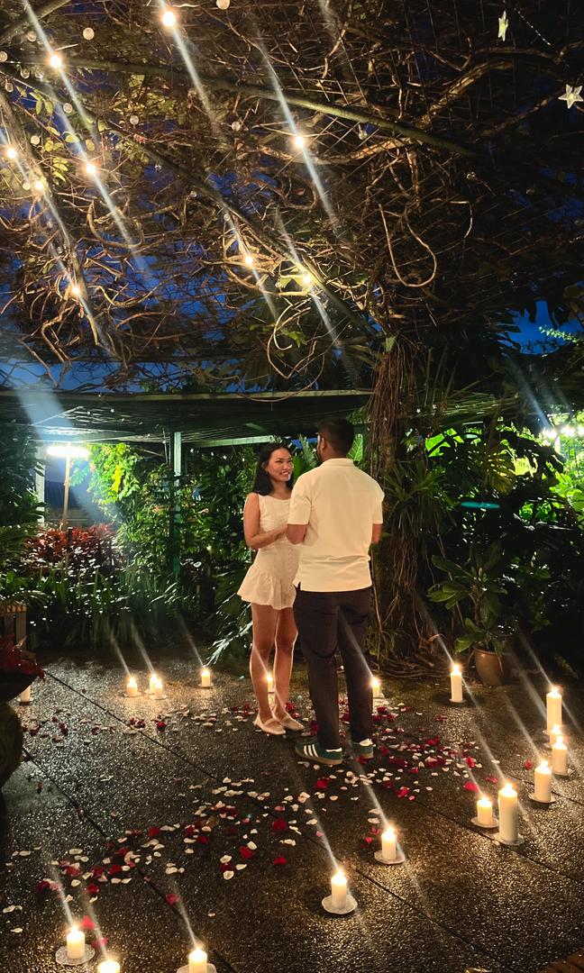 Kevin proposing on one knee surrounded by candles